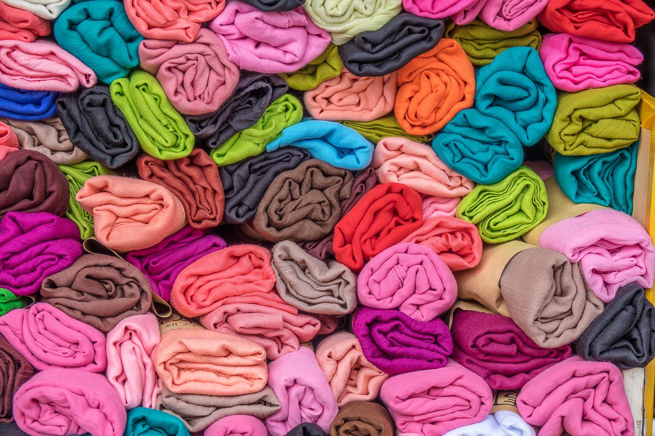 Vibrant rolled fabrics in various colors, showcasing textile diversity and market choices.
