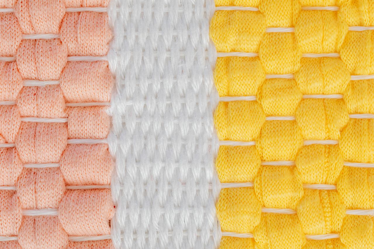 Detailed view of intertwined threads in vibrant colors on fabric.